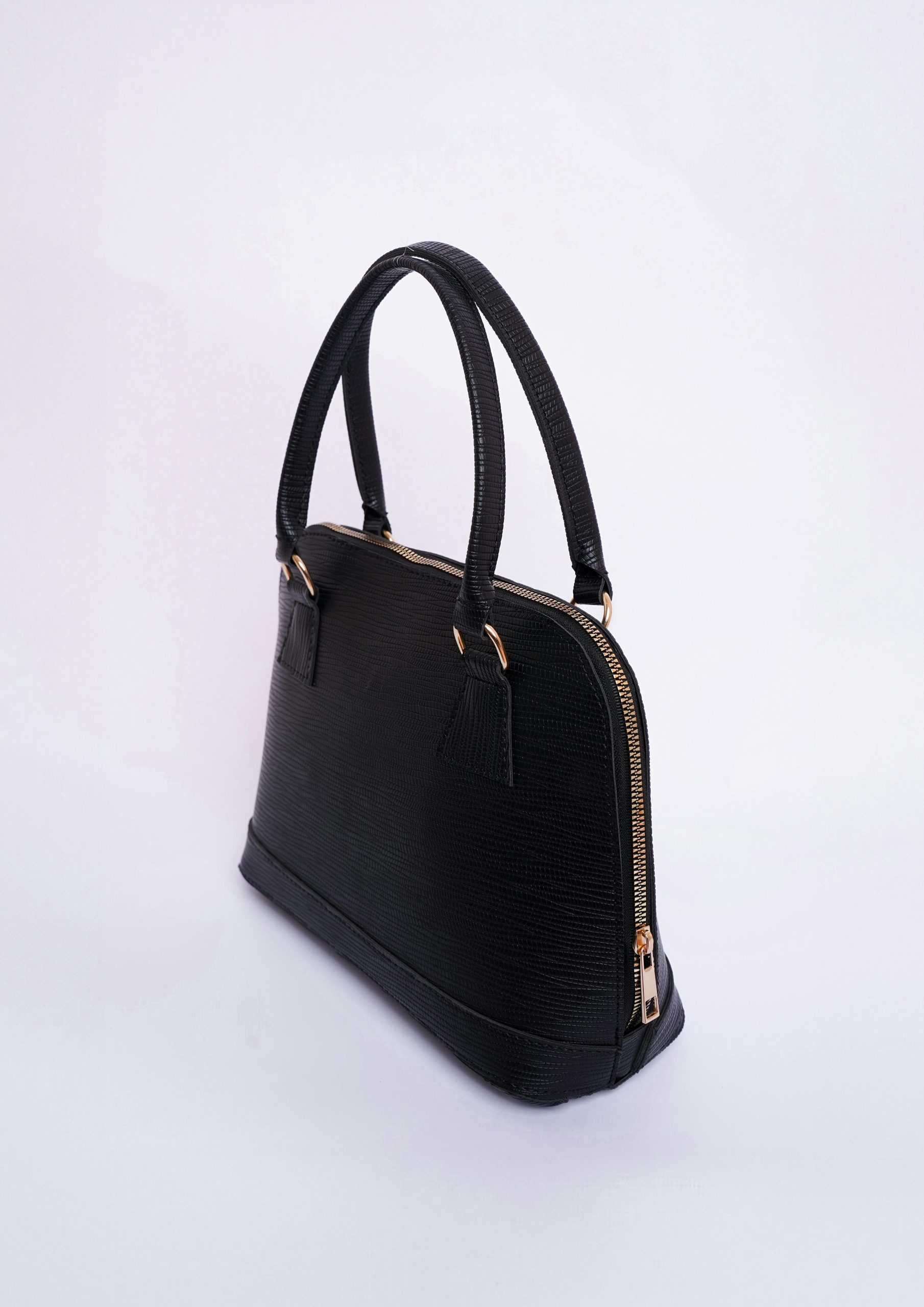 Sophisticated black fashion handbag with gold accents on a bright white backdrop.