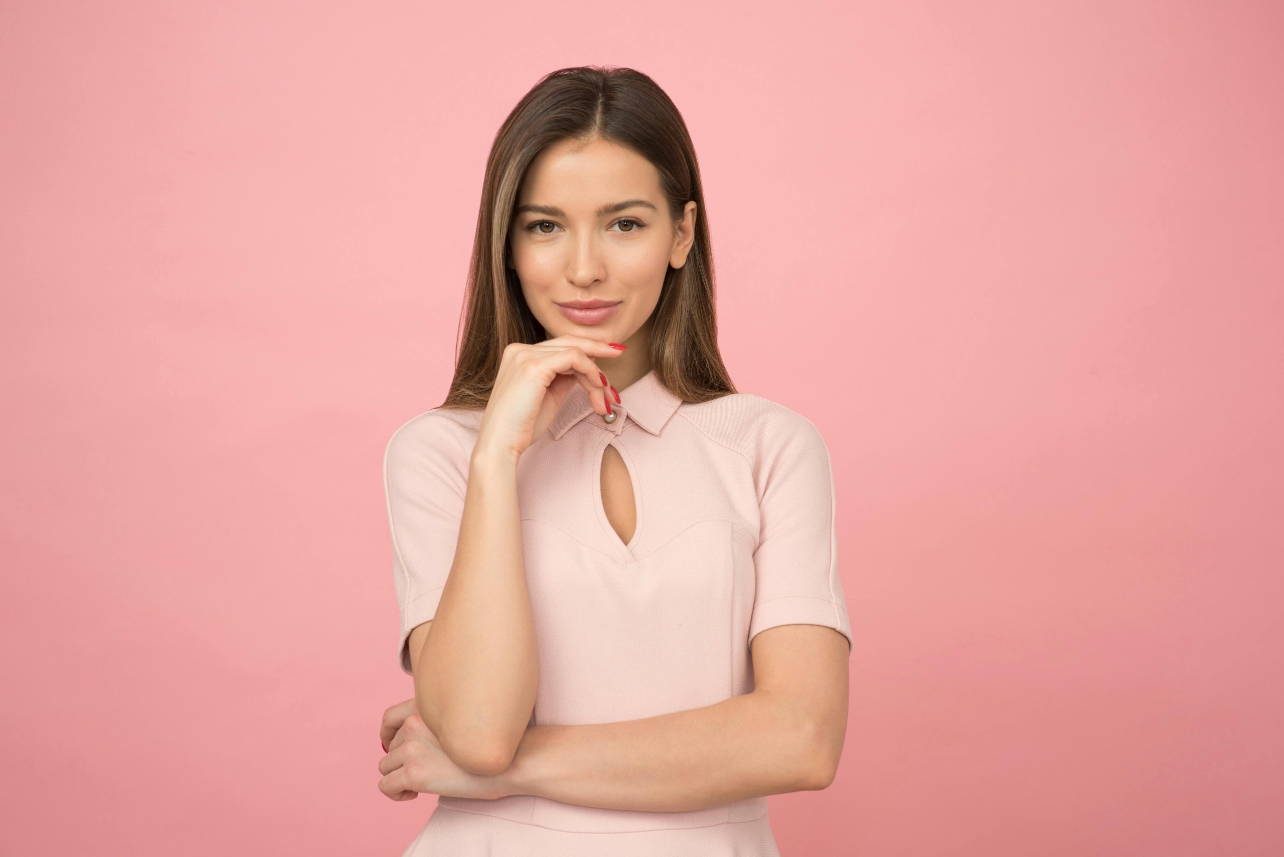 pexels-photo-1036623-1036623 - 快客Quick-洗鞋洗包到府收件 Portrait of a young woman posing elegantly in a studio with a pink background.